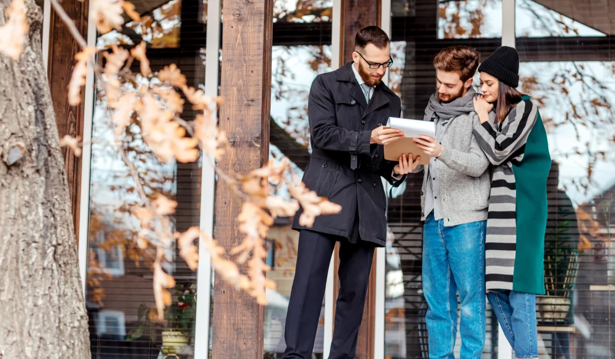 young-couple-with-real-estate-agent-near-house